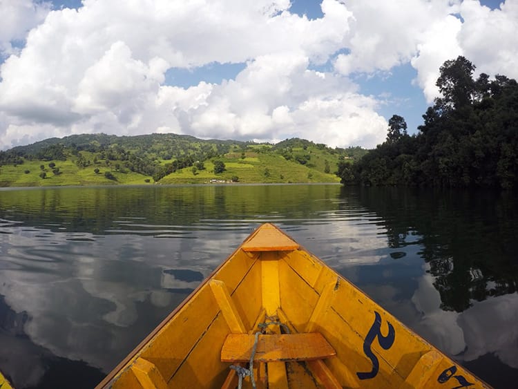 A yellow boat glides across Begnas Lake