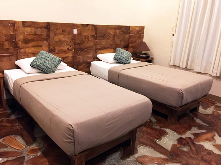 Two twin beds in a homestay in Bali with unique wood floors