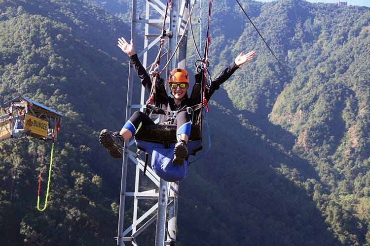 Michelle Della Giovanna from Full Time Explorer sitting in her harness at the end of the zipline in Nepal