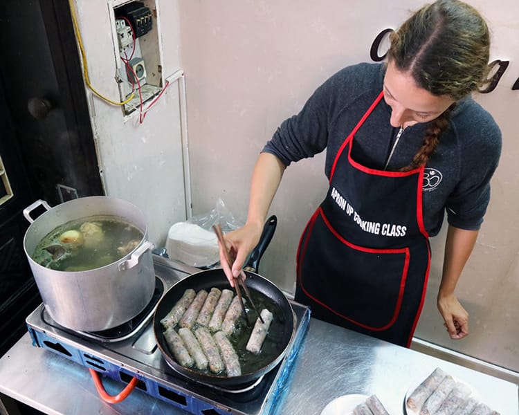 Michelle Della Giovanna from Full Time Explorer fries spring rolls in a Vietnamese cooking class