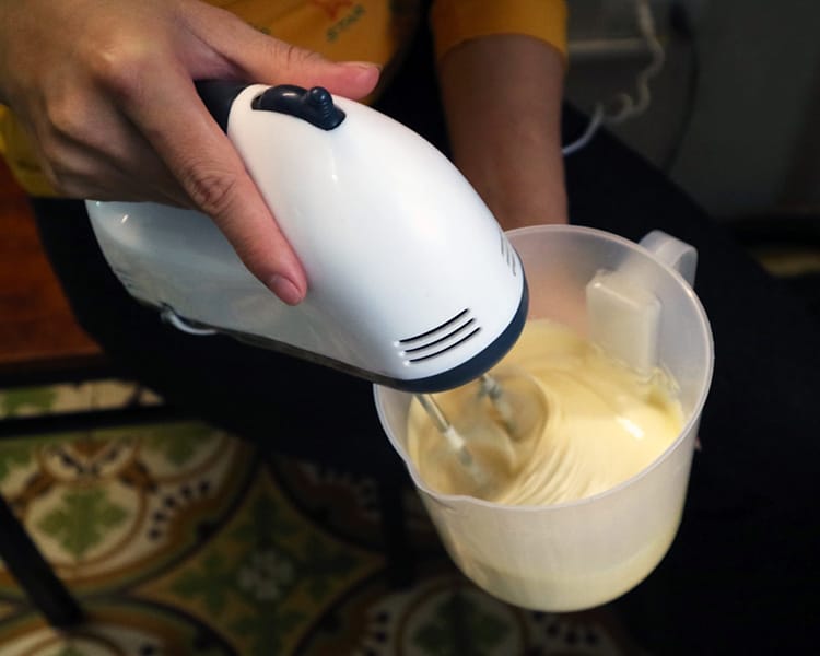A hand mixer whips cream for an egg coffee in Vietnam