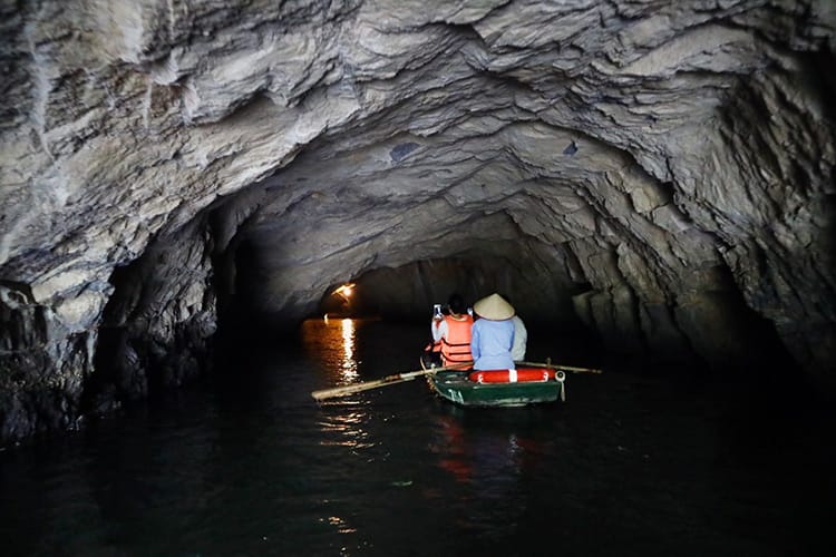 A boat goes into a cave during the Trang An Boat Tour