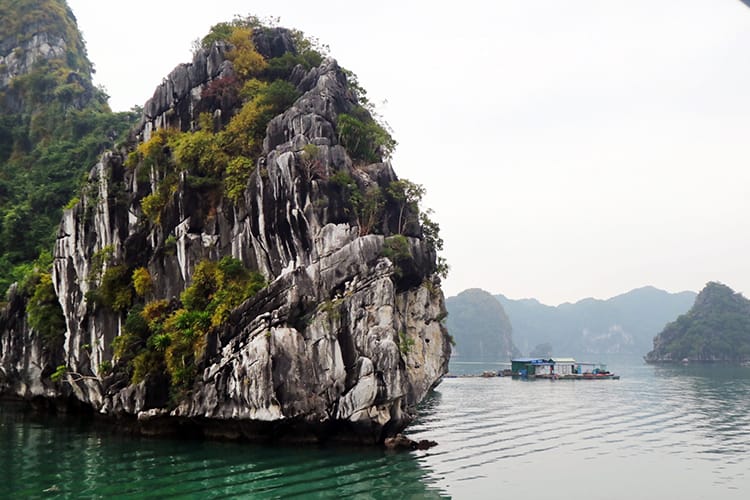 A giant limestone rock sticks out of the water in Halong Bay, Vietnam