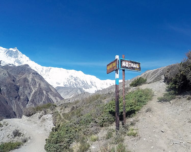 A sign on the Annapurna Circuit that says "No Trail" while pointing to a trail