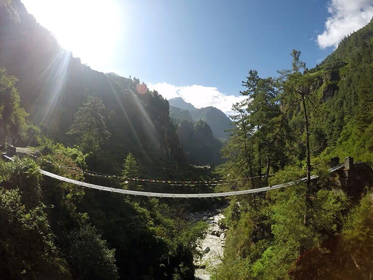 A suspension bridge crosses a river on the Annapurna Circuit