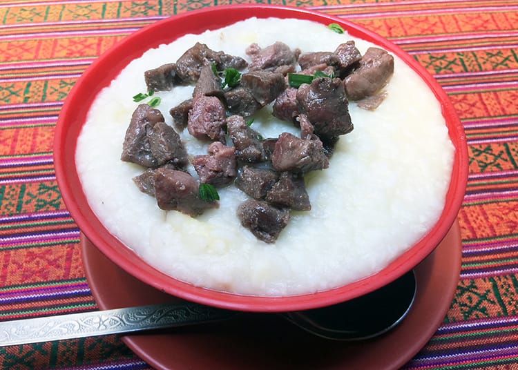 Khoo which looks like grits with red meat served on top