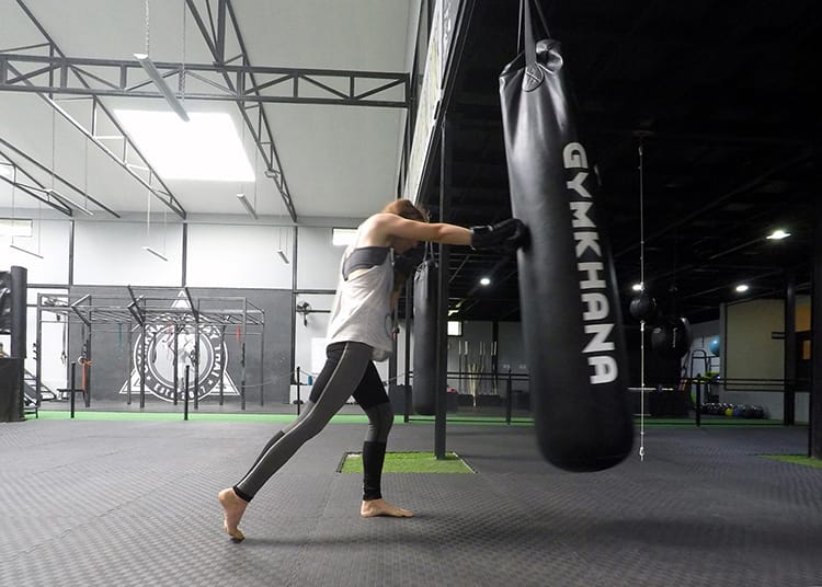 Michelle Della Giovanna from Full Time Explorer practices throwing punches on a heavy weight bag