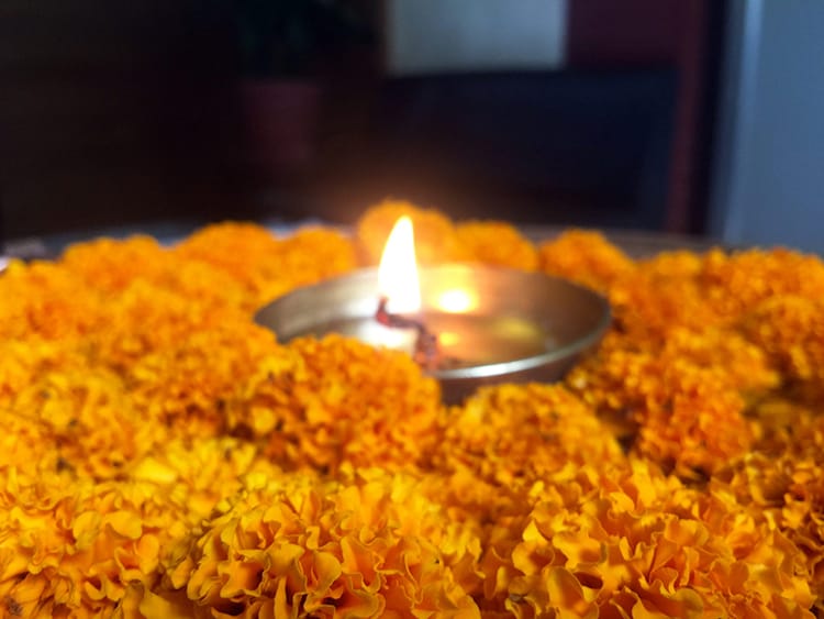 A candle surrounded by marigolds inside the spa
