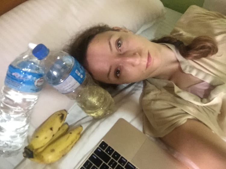Michelle Della Giovanna from Full Time Explorer lays sick in bed