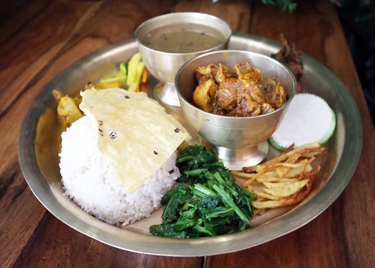 A traditional meal in Nepal is Dal Baht which has rice, spinach, chicken curry, potato frieds, radish, lentil soup, and a pickle