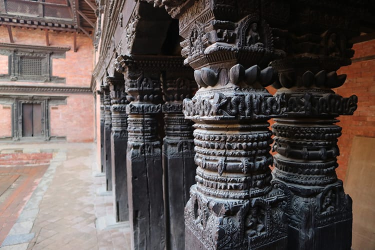 A close up of wood pillars in the Patan Durbar Square Museum which shows the special wood carvings of the Newari caste
