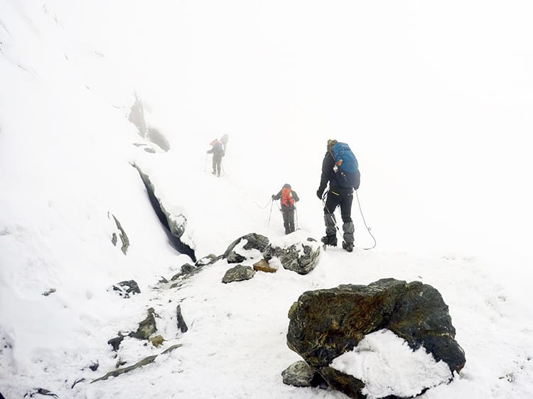 Mountain climbers disappear into white out conditions as they head up fixed ropes on the way to Mera Peak