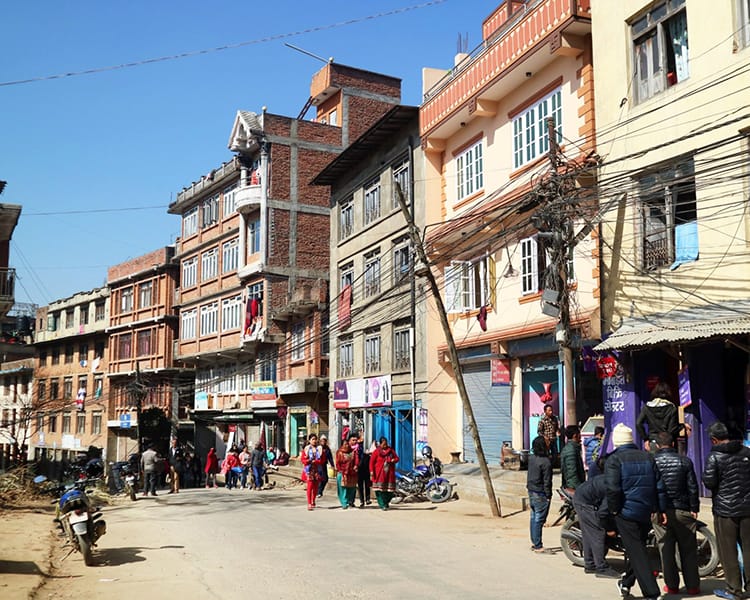 The busy street of the old city of Dhulikhel where people are walking to different shops