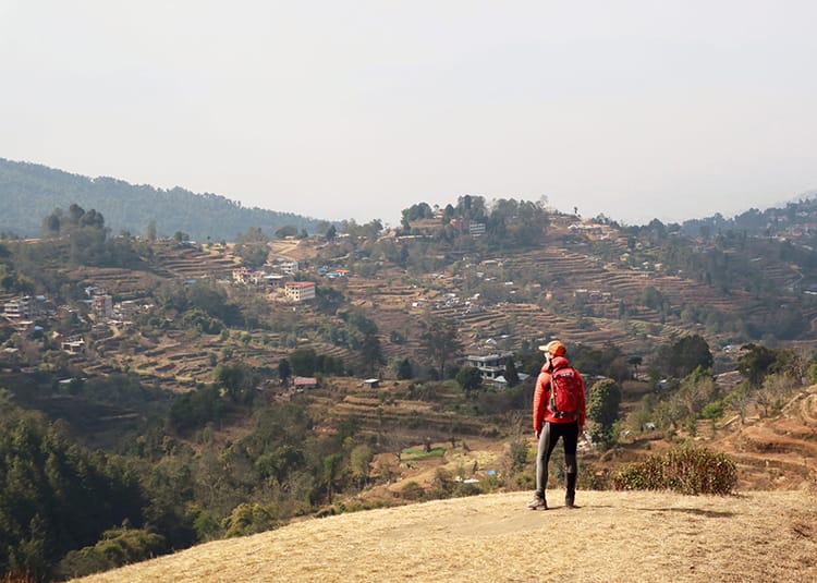 Michelle Della Giovanna from Full Time Explorer stands looking out at the view on the hike from Nagarkot to Dhulikhel in Nepal