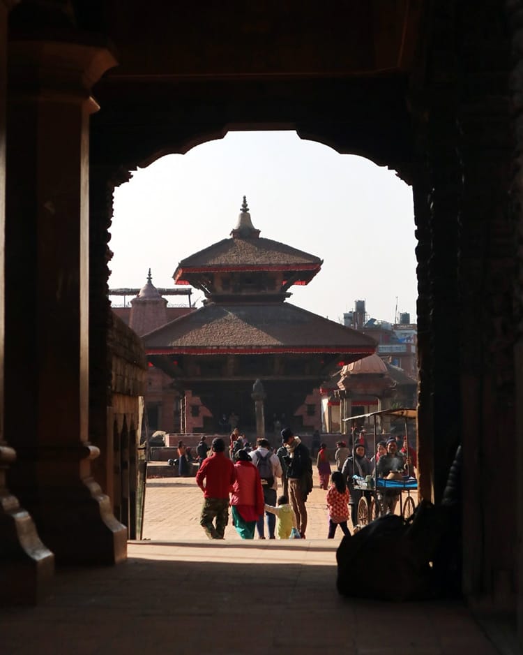 The silhouette of an archway with a temple in Bhaktapur Durbar Square framed in the center