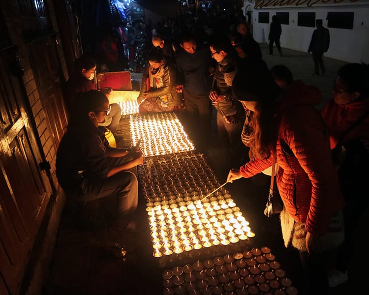 Michelle Della Giovanna from Full Time Explorer lights a candle during the Losar festival in Kathmandu