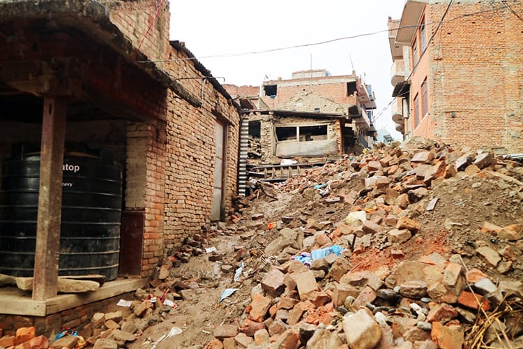 Bricks and dirt block a road years after the earthquake in Nepal