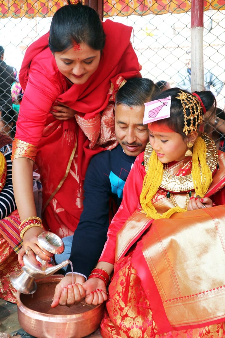 A Newari family performs puja during an Ehee ceremony where their daughter marries a bel fruit