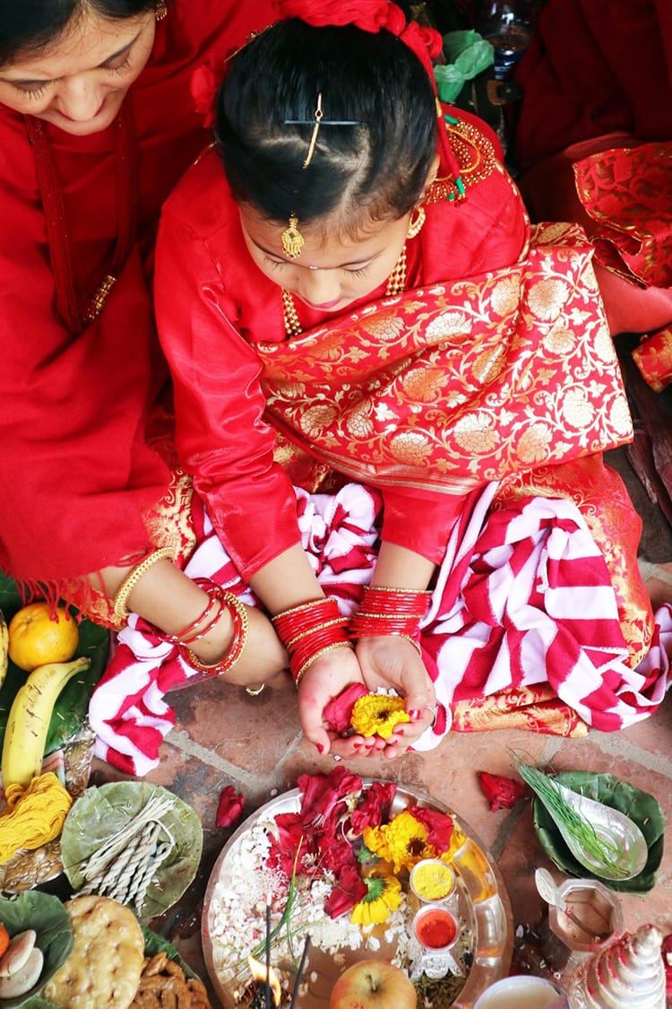 A newari girl holds flowers in her hands during the Ihi ceremony