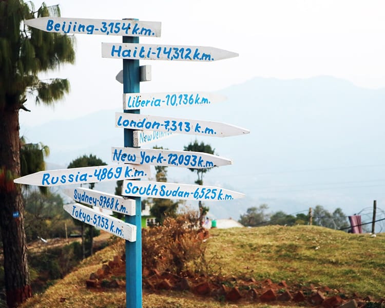 A sign pointing to different destinations all over the world
