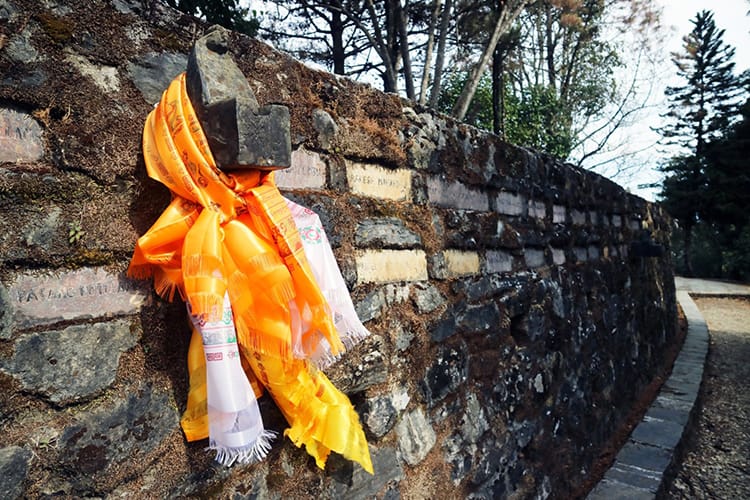 A golden colored scarf hangs from the crash monument in Kakani Nepal