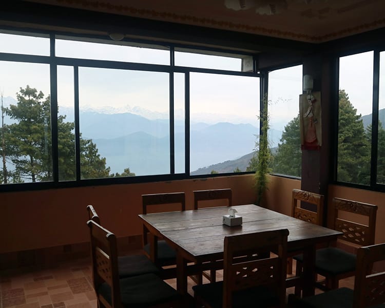 A restaurant with glass windows where you can see the Himalayan mountains in Kakani