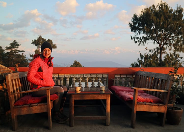 Michelle Della Giovanna from Full Time Explorer sits drinking tea at the Peacful Cottages in Nagarkot during the Kathmandu Valley Trek