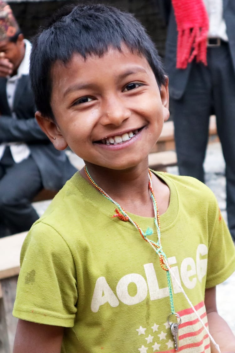 A young boy in Kaina Bazaar smiles for a photo