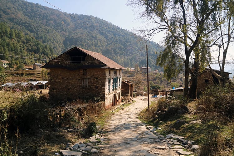 A small stone home sits along the stone pathway in Chitlang
