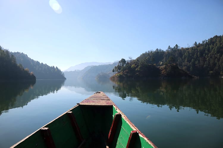 A boat glides across the glassy surface of Kulekhani Reservoir in the morning.
