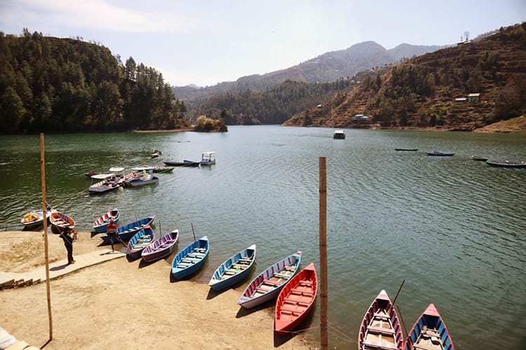 Colorful boats lined up on the edge of the Kulekhani Reservoir in Markhu