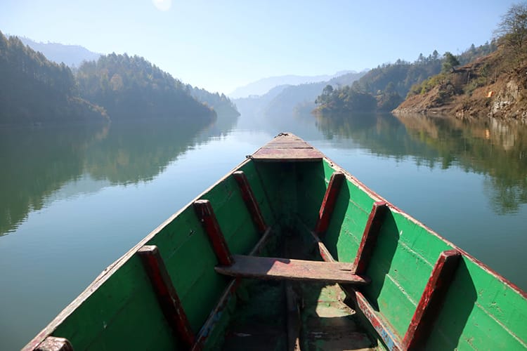View from the front of a row boat going down the glassy Kulekhani dam while leaving Markhu