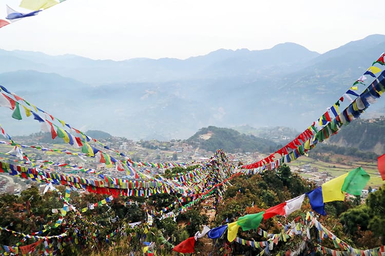 Thousands of prayer flags are draped over the hiking trail on the way to Asura Cave