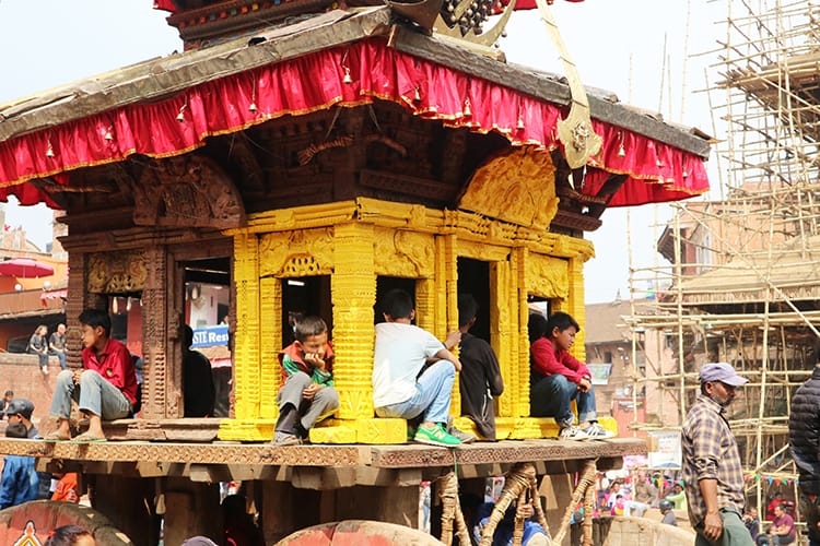 Young children sit in the chariot as it gets prepared for the festival