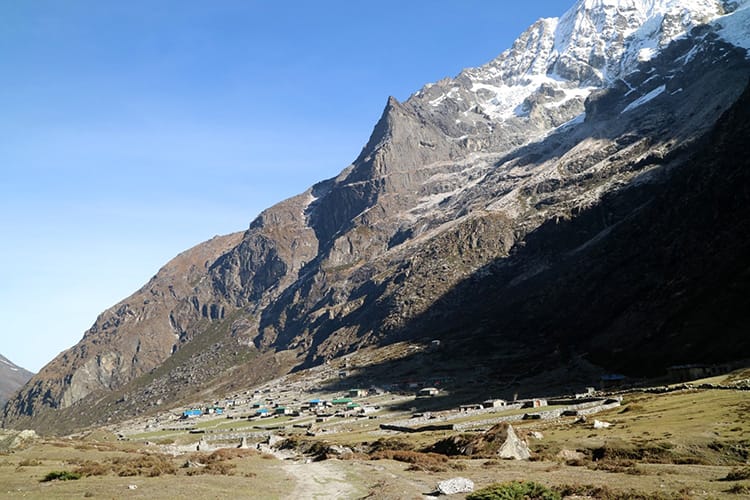 the village of Na, Nepal from a distance with giant rocky hills towering nearby