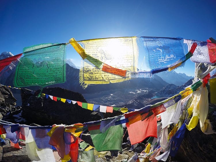 Prayer flags hang from a stupa in the mountains