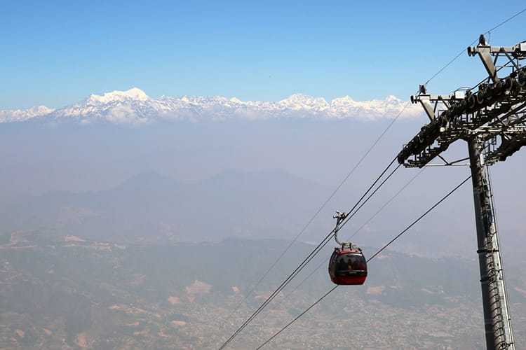 A cable car ascends up the Chandragiri Cable Car with the Himalaya in the background