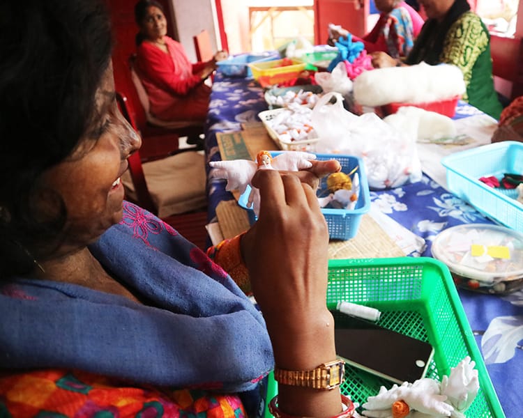 A women makes an angel out of fabric to give to donors