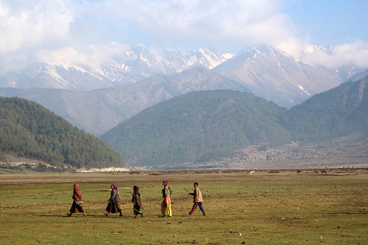 Five people walk across a field in the Dhorpatan Hunting Reserve in Nepal in April