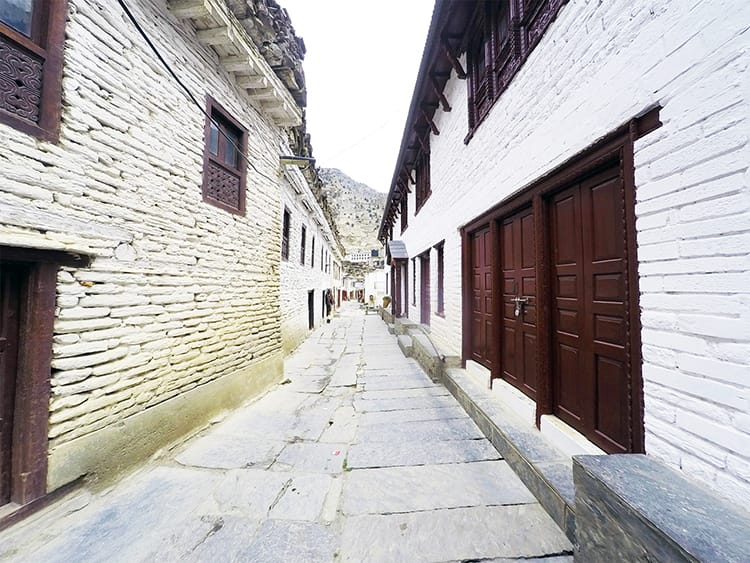 A street in Marpha with stone streets and white stone buildings lining the pathway