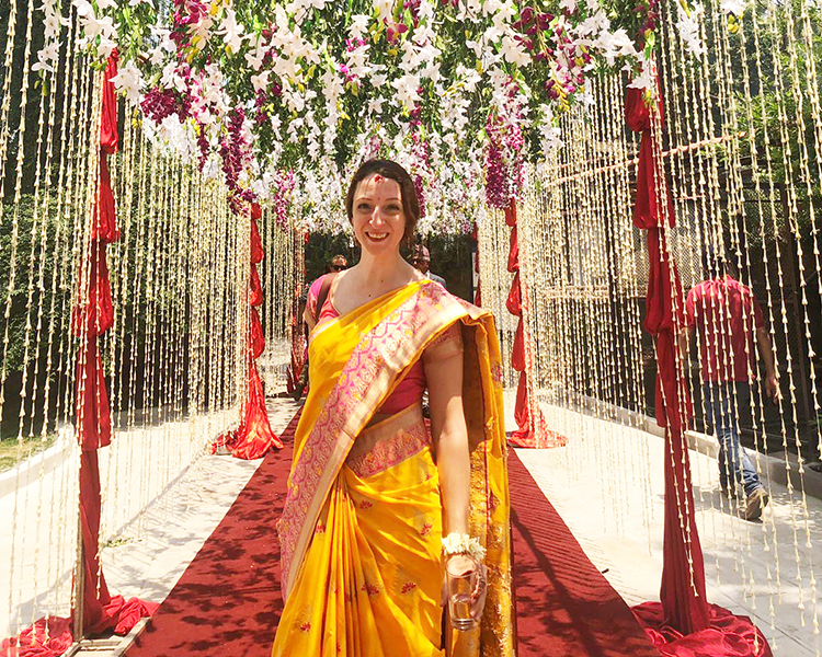 Michelle Della Giovanna from Full Time Explorer wearing a yellow and pink saree