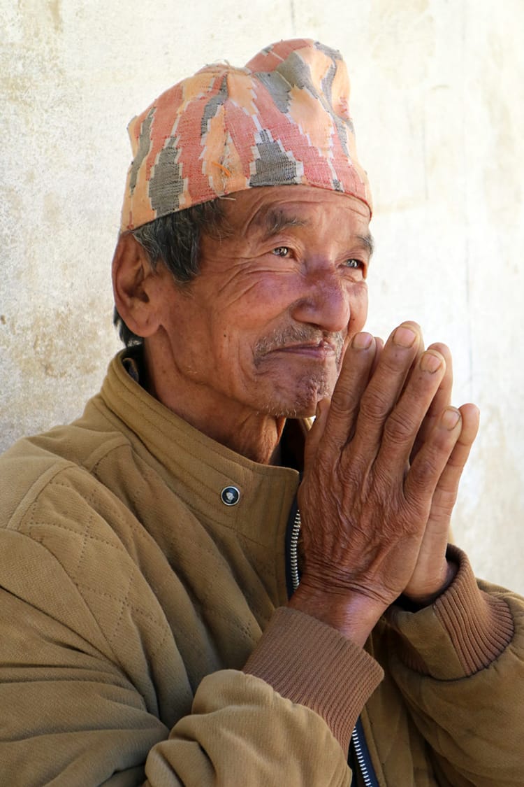 A man in Nepal holds his hands in prayer as saying Namaste
