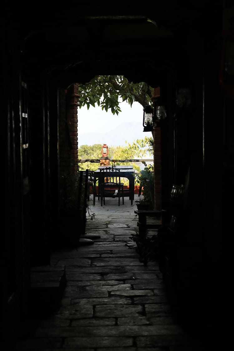 A small corridor leading out to a patio with a view of the Himalaya