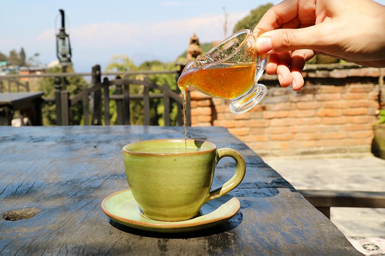 A cup of ginger lemon honey tea served on the patio at The Old Inn in Bandipur