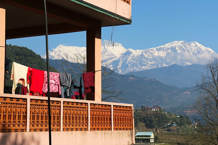 Bright laundry hangs from a balcony in front of the Himalaya