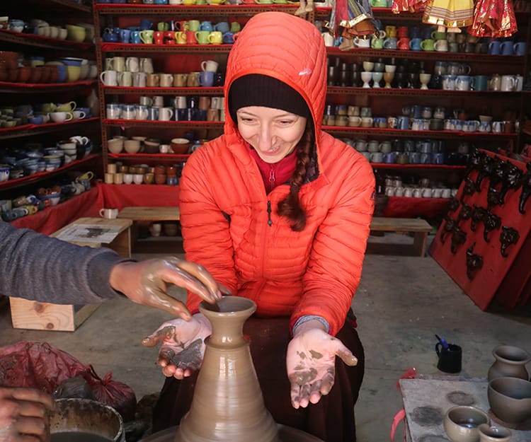 Michelle Della Giovanna from Full Time Explorer tries to make a small piece of pottery on a wheel but needs help
