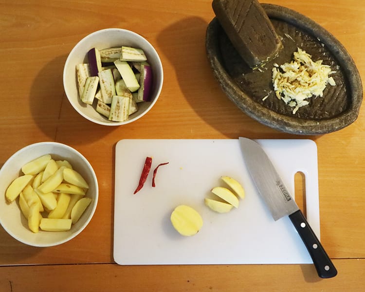 Ingredients being prepped for dry brinjal curry