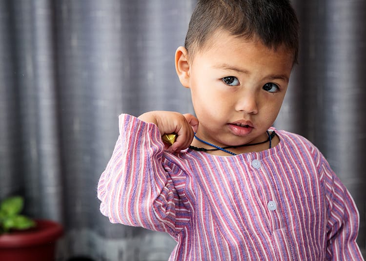 A child wears an outfit made by Kokroma from Nepal