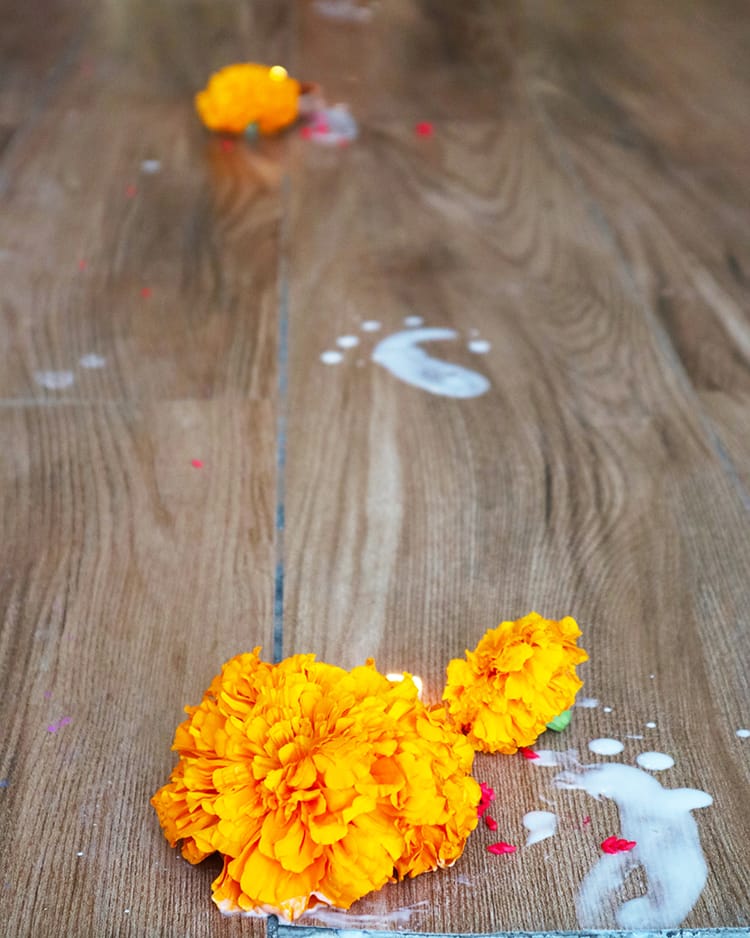 Small footprints made out of flour and water lead the way to the entrance for Laxmi