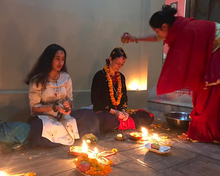 Michelle Della Giovanna from Full Time Explorer gets flowers poured over her head during her first Mha Puja